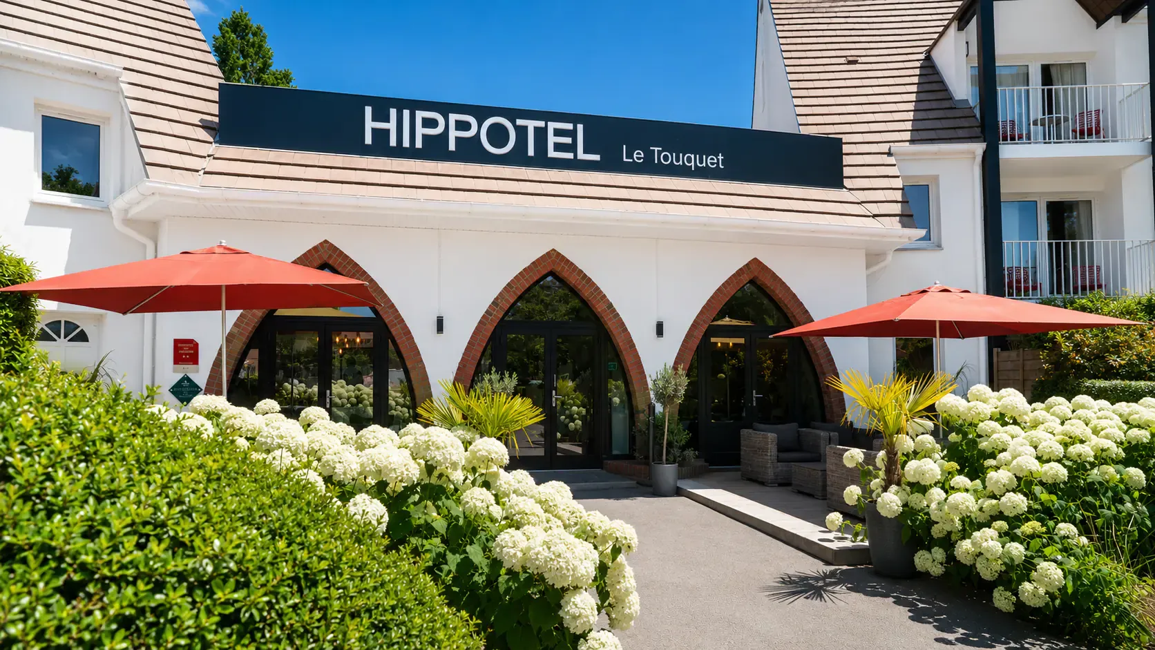 L'entrée de l'Hippotel sous les parasols, côté terrasse