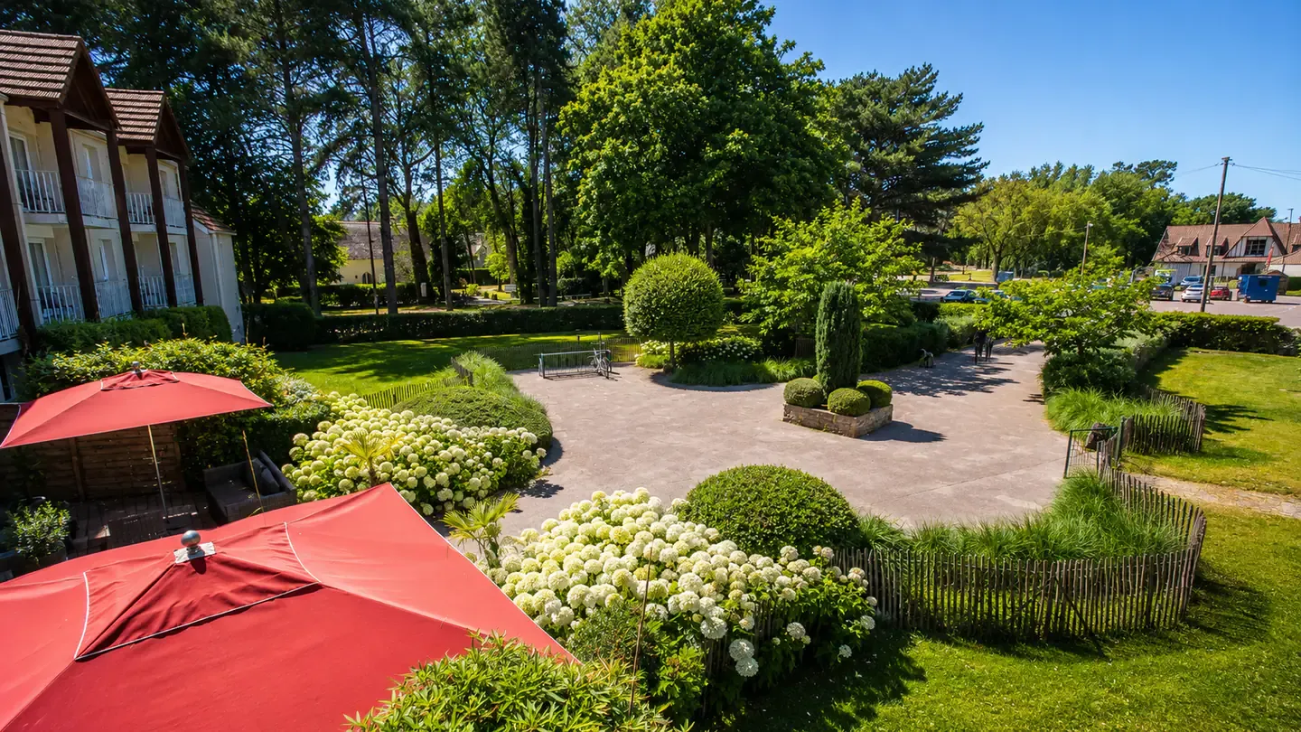 Le jardin de l'Hippotel et ses parasols, côté forêt